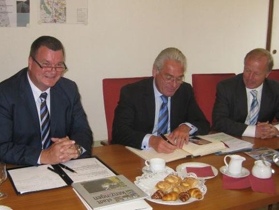 Bürgermeister Matthias Guderjan, Innenminister Heribert Rech trägt sich ins Gästebuch ein 